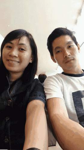 a man and a woman are posing for a picture and the man is wearing a shirt that says l on it
