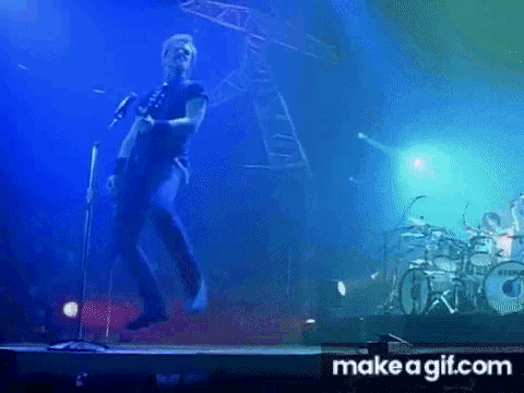 a man playing a guitar on a stage with a make a gif.com link