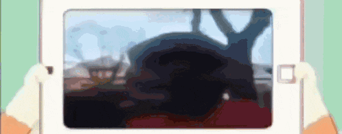 a person is holding a tablet with a blurry picture of a person on it .