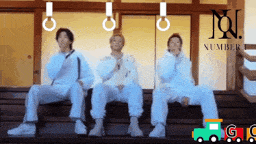 three people are sitting in front of a sign that says number one