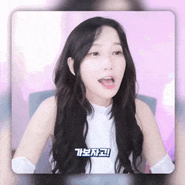 a woman with long black hair is sitting in front of a pink background with chinese writing on it