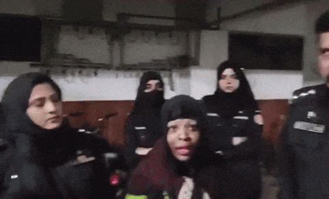 a woman with pink lipstick is standing in front of a group of female police officers