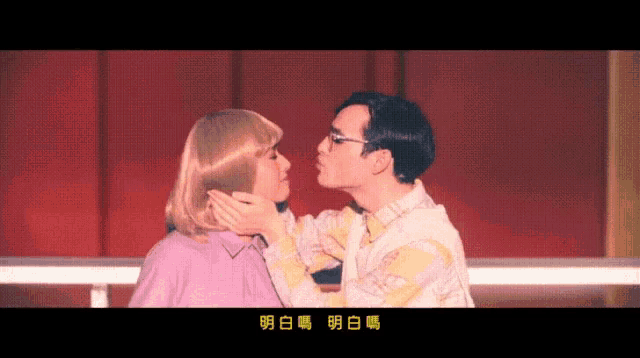 a man and a woman are kissing with chinese writing on the bottom right