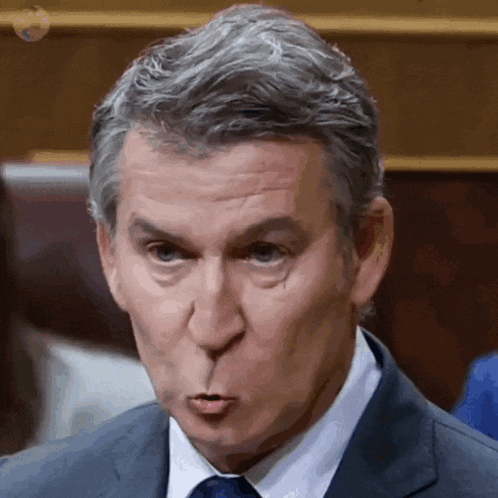 a man in a suit and tie making a face