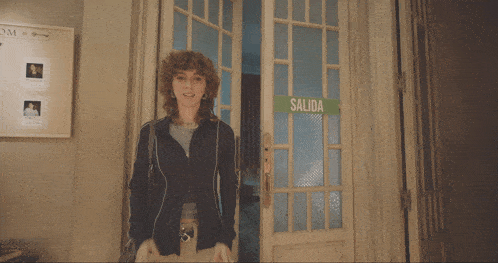 a woman stands in front of a salida sign on a door