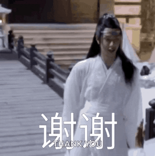 a man in a white kimono is standing on a bridge and says thank you in chinese