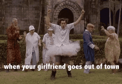 a man in a tutu is dancing with a group of older people in a park .