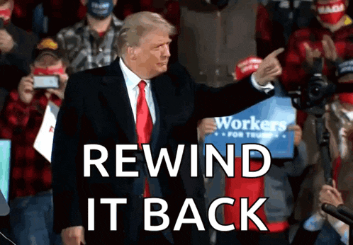 a man in a suit and tie stands in front of a crowd with the words rewind it back below him