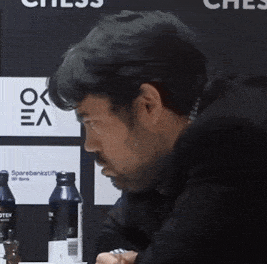 a man sitting in front of a chess board