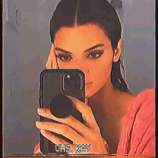 a woman is taking a picture of herself in a mirror with uhs kay written on it