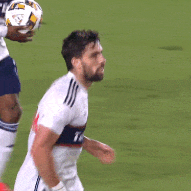 a soccer player wearing a white jersey with the letter t on the front
