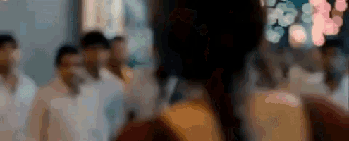 a blurry picture of a woman standing in front of a crowd .