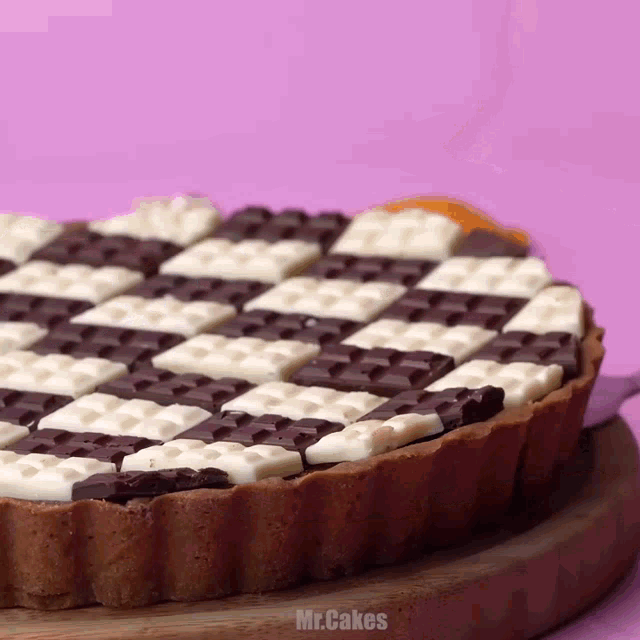 a cake with a checkered pattern and the words mr.cakes on the bottom right