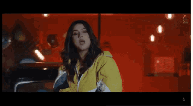 a woman in a yellow sweater is sitting in a car with her legs crossed .