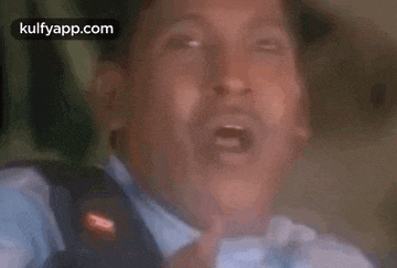 a close up of a man 's face with his mouth open and his eyes closed .