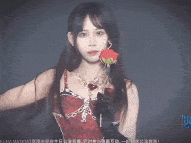 a woman in a red dress holds a rose in her hand