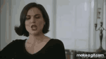a woman in a black dress is making a funny face with her tongue out .