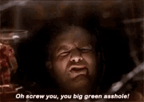 a man is screaming in a dark room with his mouth open .
