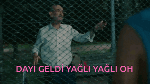 a man behind a chain link fence with dayi geldi yagli yagli oh