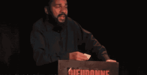 a man with a beard is making a funny face in the dark