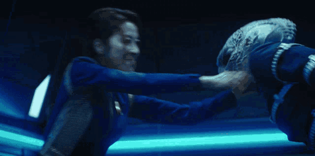 a woman in a blue suit is holding a man 's leg