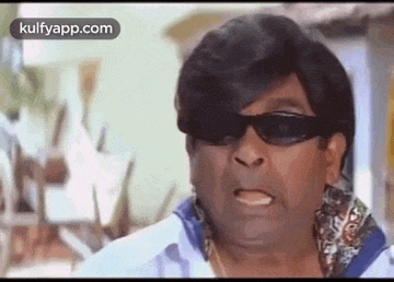 a close up of a man wearing sunglasses and a wig making a funny face .