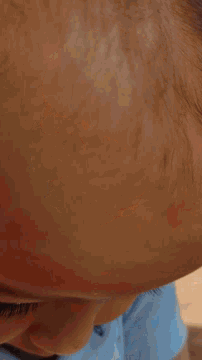 a close up of a person 's face with a shadow on the wall