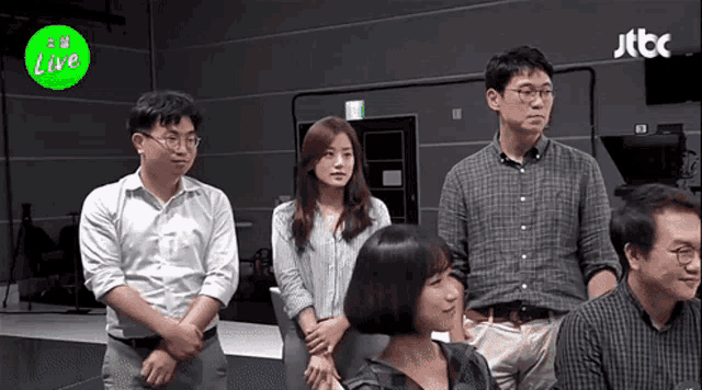 a group of people standing in front of a sign that says " live "