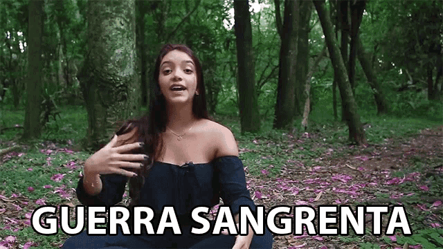 a woman sitting in the woods with the words guerra sangrenta written on the screen