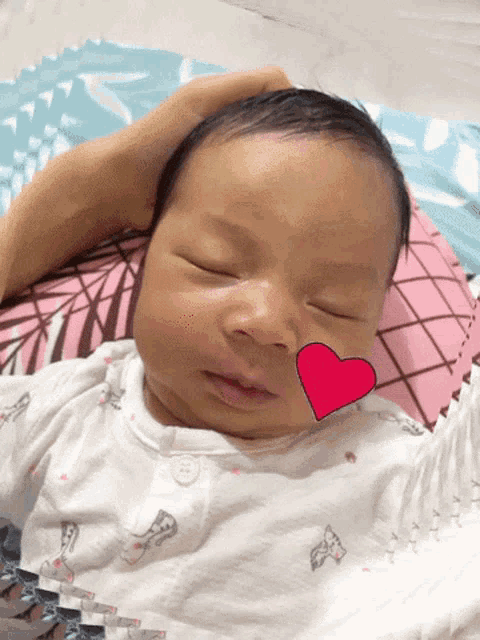 a baby with a red heart on its face