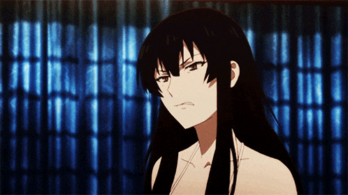 a girl with long black hair looks angry in front of a blue curtain