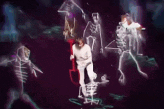 a group of skeletons are dancing in a dark room