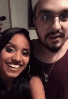 a man and a woman are posing for a picture and smiling for the camera