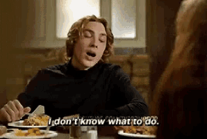 a man is sitting at a table with his mouth open and says i don 't know what to do
