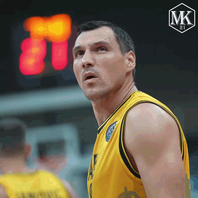 a basketball player stands in front of a scoreboard that says mk 21