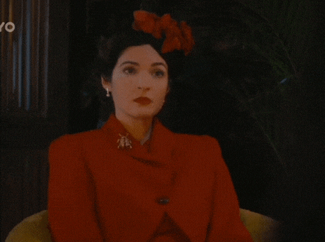 a woman in a red jacket is sitting in a chair .