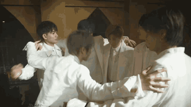 a group of men are hugging each other in a room