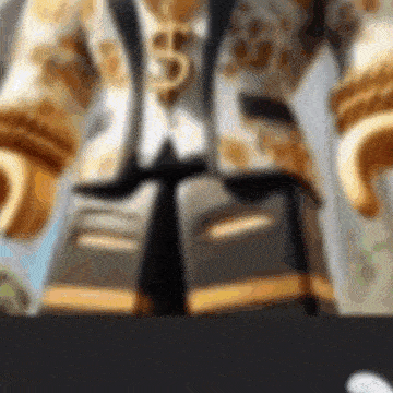 a close up of a lego figure wearing a gold suit and tie .