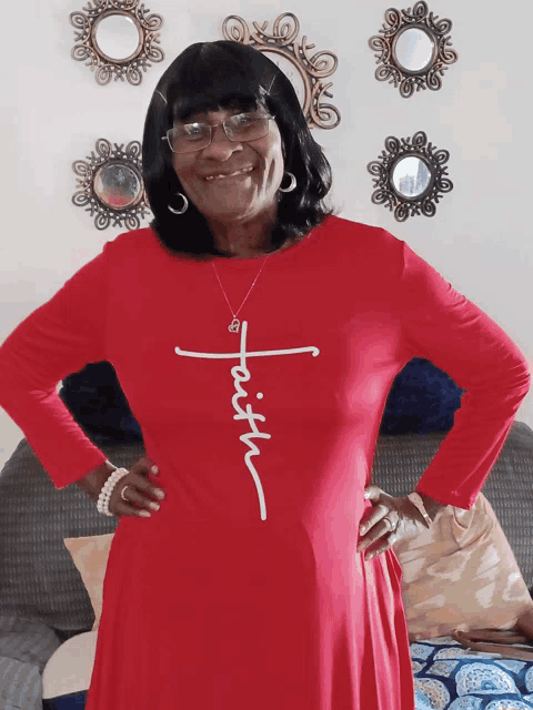 a woman wearing a red dress with the word faith on the front