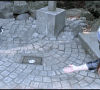 a person 's hand is reaching out towards a brick pavement