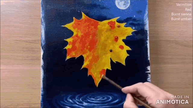 a person is painting a maple leaf on a canvas that is made in animatica