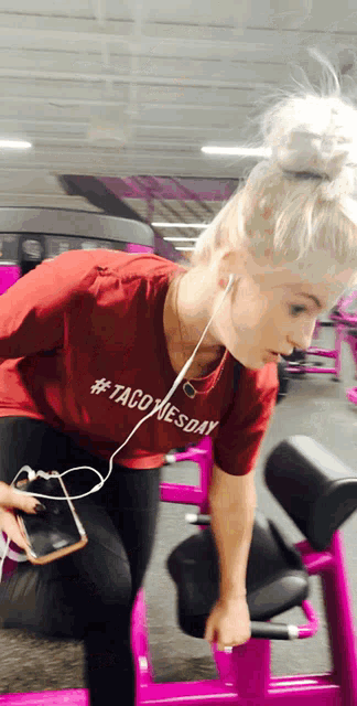 a woman wearing a #taco tuesday t-shirt is lifting weights