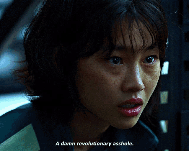 a close up of a woman 's face with the words a damn revolutionary asshole below her