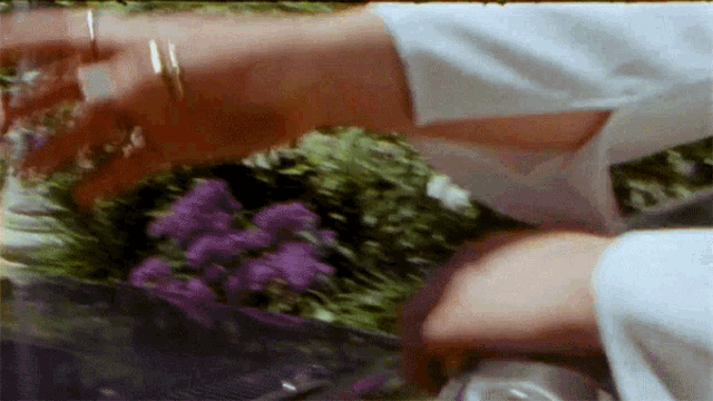 a blurry picture of a person holding a bouquet of purple flowers