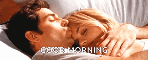 a man kissing a woman in bed with the words good morning below