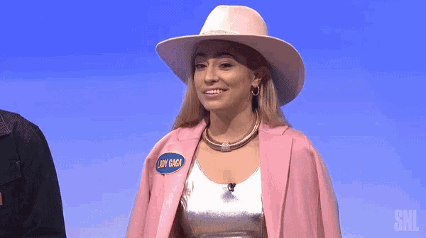 a woman wearing a pink hat and a pink jacket with a name tag that says lady gaga
