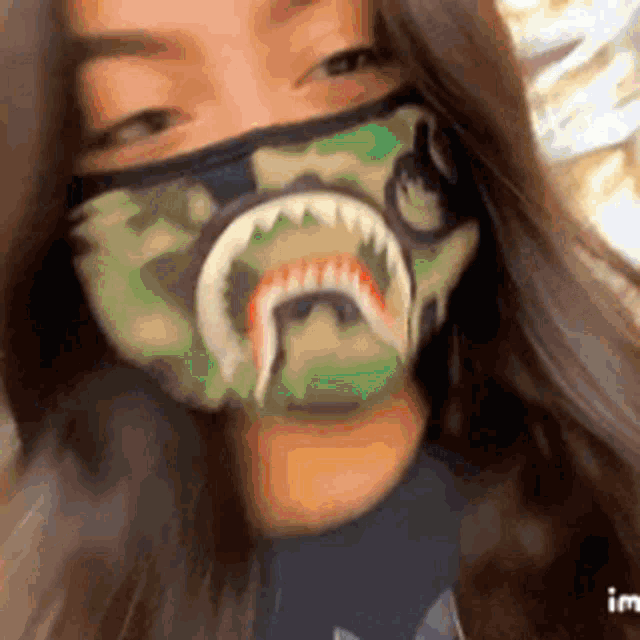 a woman wearing a mask with a shark on it .