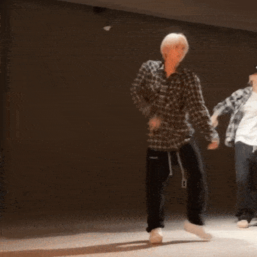 two people are dancing in a dark room .