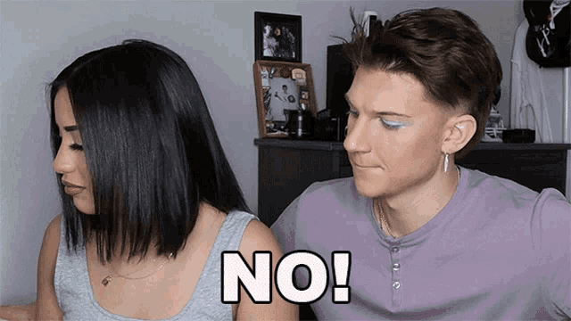 a man and a woman are sitting next to each other and the word no is visible
