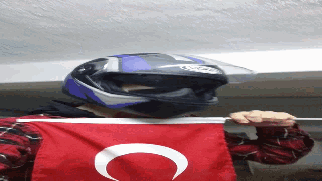 a person with a helmet on holding a small flag